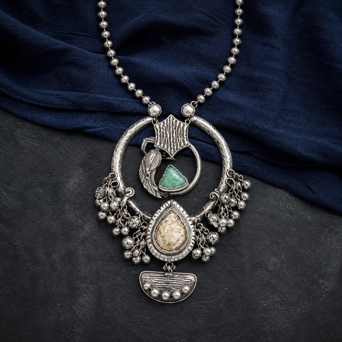Talisman Orbit Necklace arranged on sculptural stone