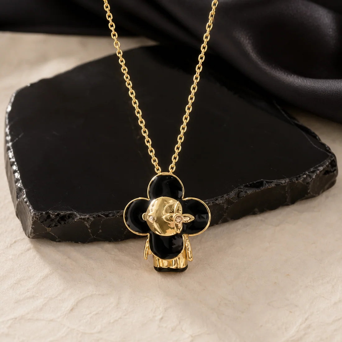 Noir Visage Pendant on a textured surface
